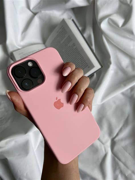 a person holding a pink iphone case with an apple logo on it