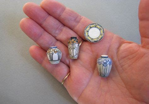 four small ceramic vases in the palm of someone's hand