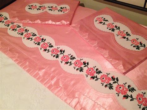 three pink bedspreads with flowers on them