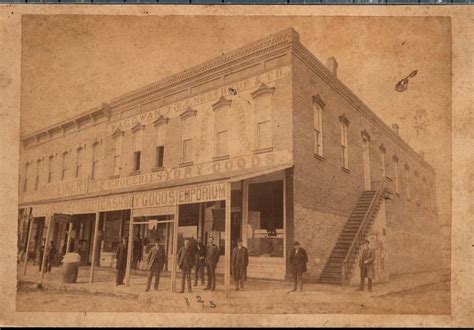 an old photo of people standing in front of a building