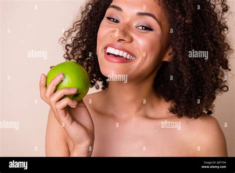 Photo of cheerful sweet lady wear nothing enjoying juicy fruit smiling isolated beige color ...