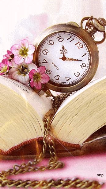 an open book with pink flowers and a pocket watch
