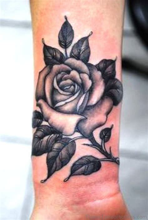 a black and white rose tattoo on the wrist