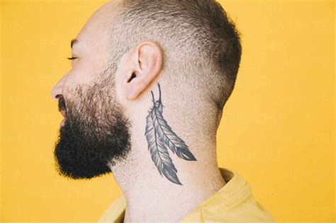 Close-up of neck tattoo on man against colored background stock photo