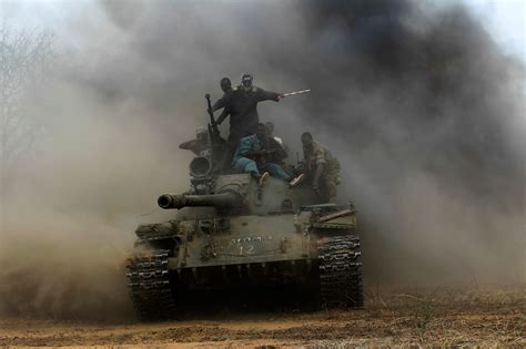 Sudanese Armed Forces and Rapid Support Forces personnel ride on a T-54/55 tank after ...