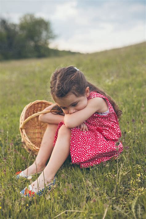 Sad Little Girl Sitting In Grass by Dejan Ristovski