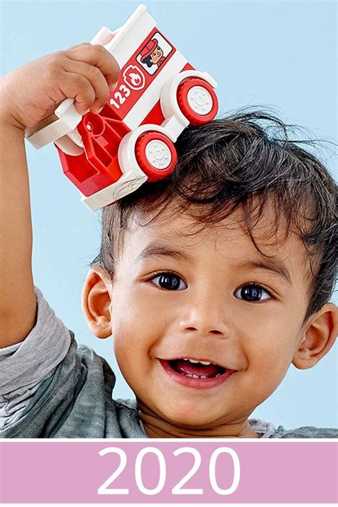 a little boy holding a toy truck on top of his head with the words happy new year written below it