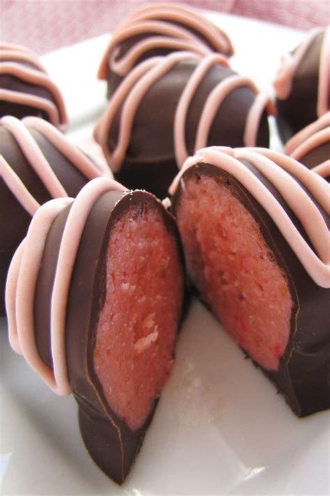 chocolate covered donuts with pink and white icing on a plate