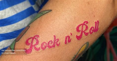 "Rock n' Roll" lettering tattoo located on the forearm.