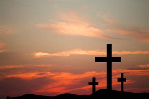 Three wooden crosses in silhouette stand silently on a hill at | Jesus ...