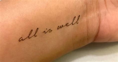 "All is well" temporary lettering tattoo located on the