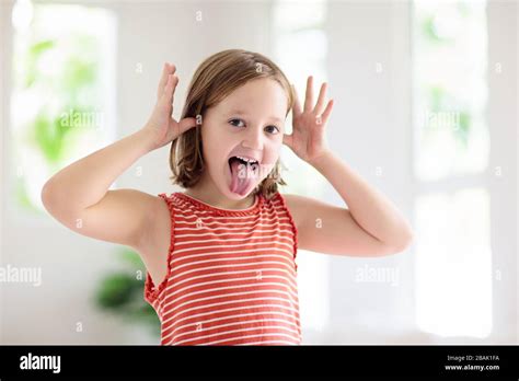 Child making funny face. Kid teasing and laughing. Silly little girl playing and smiling Stock ...