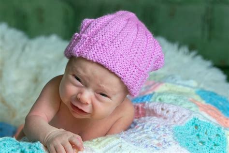 Premium Photo | Newborn baby with funny face little baby in pink cap is ...