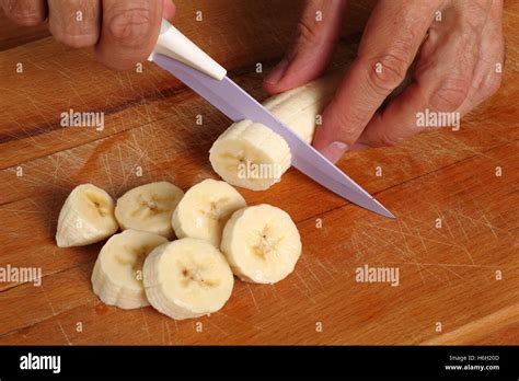 Slicing peeled banana Stock Photo - Alamy