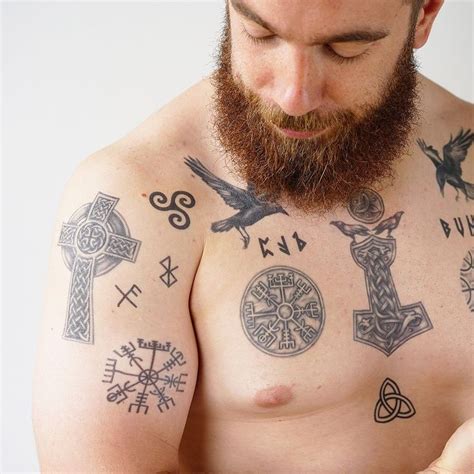 a man with tattoos on his chest holding a cell phone