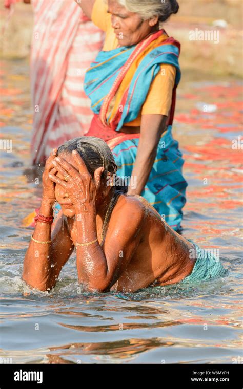 Indian Hindu women wearing saris perform early morning bathing rituals ...