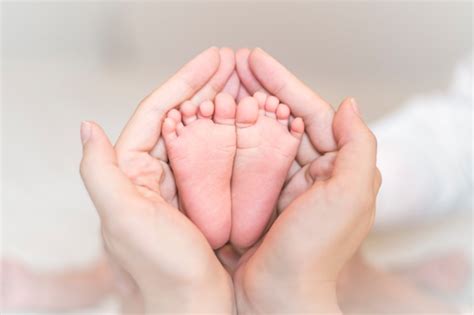 Close-up dos pés do bebê recém-nascido nas mãos femininas | Foto Premium