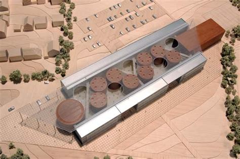 an aerial view of a building made out of wood and metal, with several circular objects on the roof