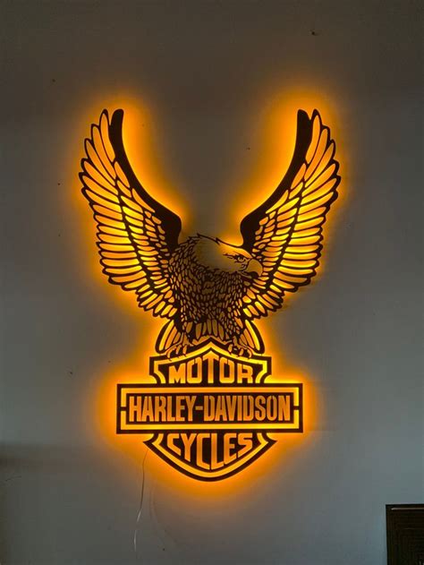 a harley davidson neon sign mounted to the side of a wall