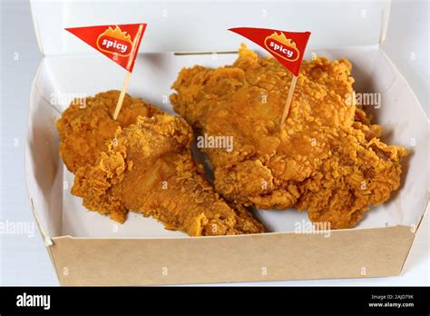 A Jollibee "Chickenjoy!" 2-piece spicy fried chicken in a paper take-out container Stock Photo ...