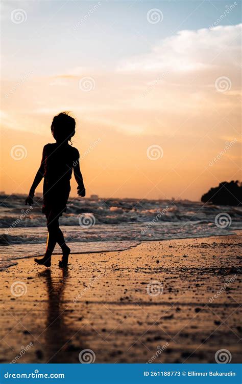 Silhouette of a Child Walking by the Beach during Golden Sunset Stock ...