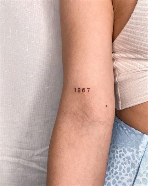 "1967" lettering tattoo located on the bicep.