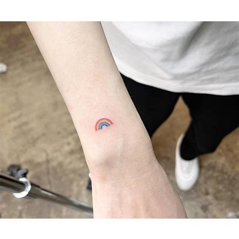 Tiny rainbow tattoo done on the wrist, minimalistic