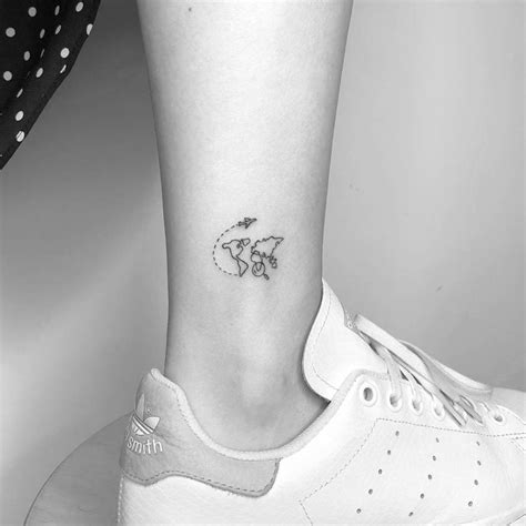 Small world map tattoo on the ankle.
