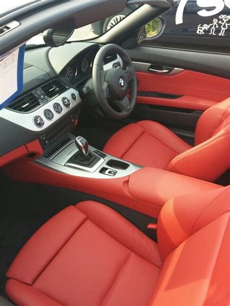 the interior of a sports car with red leather seats and steering wheel, including dashboard