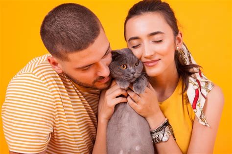 Premium Photo | Happy young couple with their well-groomed cats poses ...