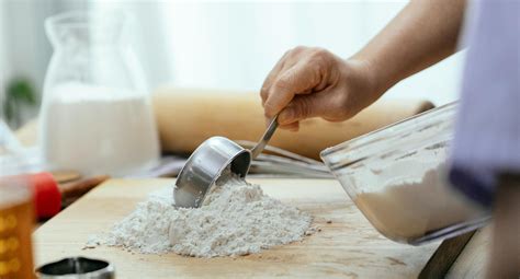 Crop adult woman adding flour on wooden cutting board · Free Stock Photo
