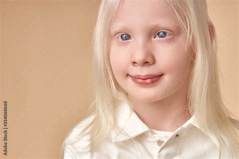 adorable albino girl 7-9 years old posing at camera isolated. shy ...