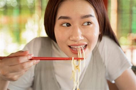 Free Photo | Front view smiley woman eating noodles