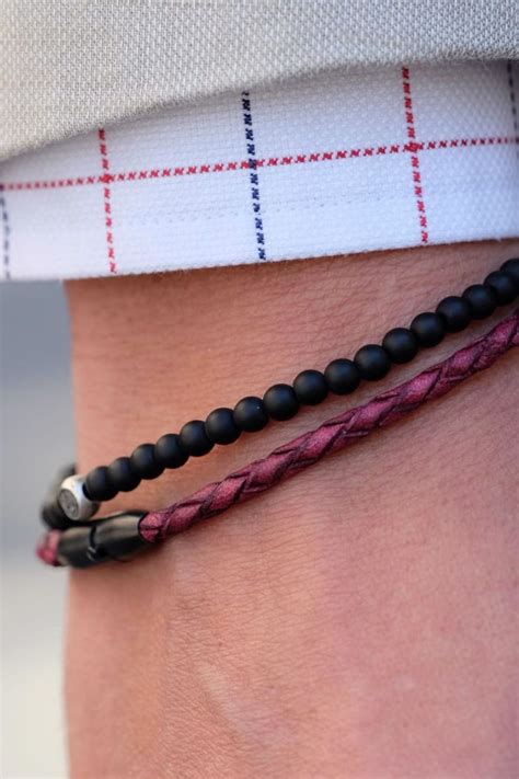 Two bracelets combined for a bold, eye-catching look. The first, in burgundy genuine woven ...