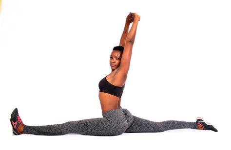 Flexible woman doing yoga split exercise