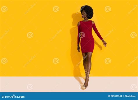 Happy Young Black Woman in Red Mini Dress and High Heels is Walking Towards Camera and Looking ...