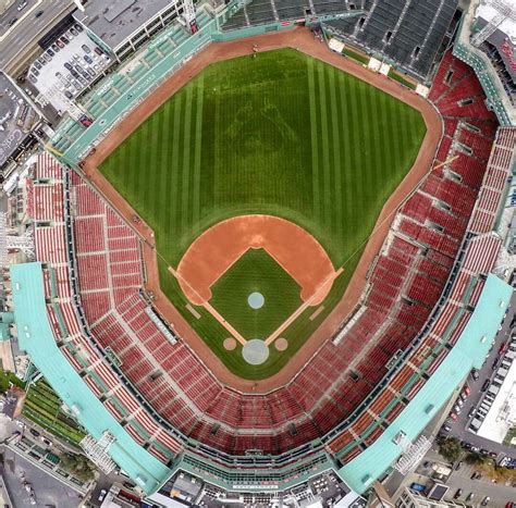 an aerial view of a baseball stadium with the field in red and green, looking down on home plate