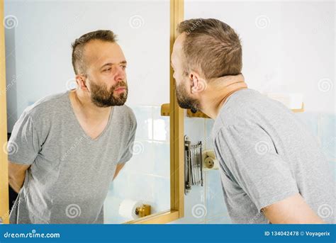 Man Looking at Himself in Mirror Stock Photo - Image of care, adult: 134042478