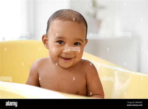 Little African-American baby washing in bathtub at home Stock Photo - Alamy