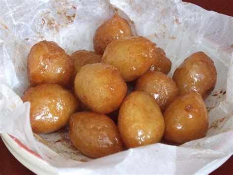 a pile of doughnuts sitting on top of a piece of waxed paper