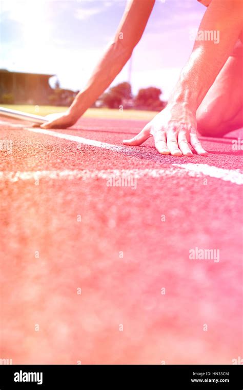 Athlete ready to start relay race on running track Stock Photo - Alamy