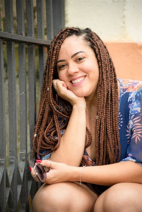 Portrait of a Pretty Woman Smiling with Braids in Her Hair and Hand on ...