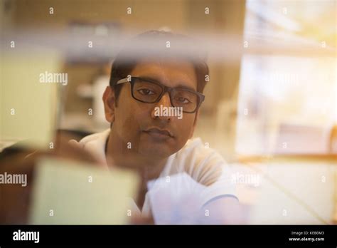 indian business male writing glass wall Stock Photo - Alamy