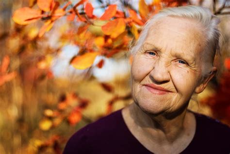 older woman with fall leaves - Wyoming Department of Health