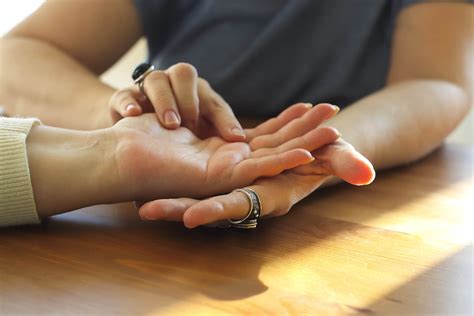 Woman visiting palmistry expert, fortune teller reading future, analyzing life lines on palm ...