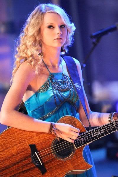 a woman in blue dress playing an acoustic guitar