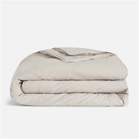 the linen sheets are folded on top of each other, with one sheet pulled down