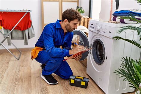 Young Hispanic Man Wearing Handyman Uniform Repairing Washing Machine ...