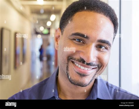 Black businessman smiling in office hallway Stock Photo - Alamy