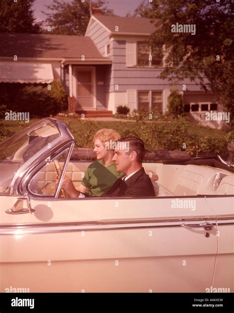 1960s COUPLE IN WHITE CONVERTIBLE CAR BY SUBURBAN HOUSE Stock Photo - Alamy